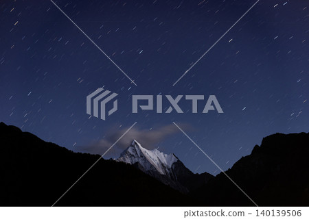 night view of snow mountain, the view of mountains.long exposure shot of the galaxy and the starry sky over mountain and lake in yading national park, daocheng county, sichuan province, china night view of snow mountain, the view of mountains.long exposure shot of the galaxy and the starry sky over mountain and lake in yading national park, daocheng county, sichuan province, china 140139506