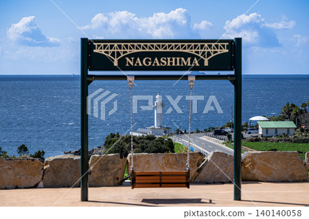 The blue sea and lighthouse as seen from the swings in the park. The blue sea and lighthouse as seen from the swings in the park. 140140058