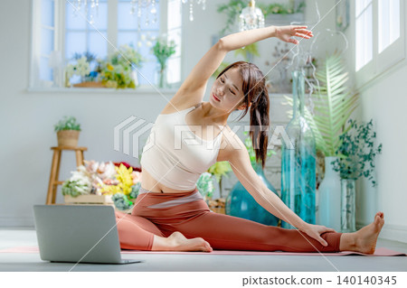 一個年輕的女人，做瑜伽在線 140140345