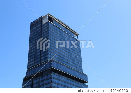 High-rise buildings in Yodoyabashi, Osaka, standing under a blue sky. 140140390