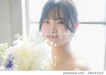 一位身穿婚紗的日本女子凝視著她的捧花。 140141022