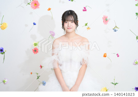 A Japanese woman in a wedding dress surrounded by flowers. 140141023