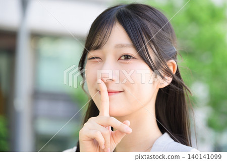 Japanese woman making a secret gesture 140141099