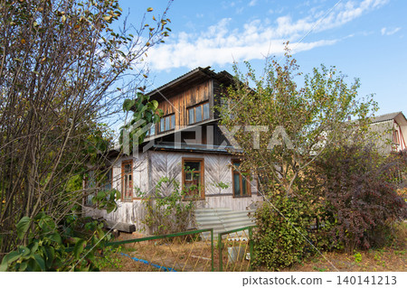 A house with many trees in front of it. The house is old and has many windows. A summer house. A house with many trees in front of it. The house is old and has many windows. A summer house. 140141213