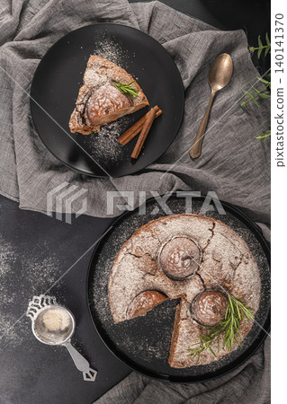 Delicious spice cake with pear, ginger and cinnamon on a dark kitchen counter. 140141370