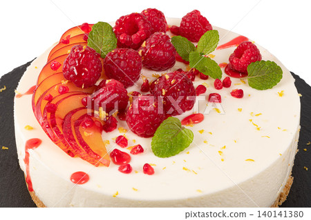 Cheesecake with raspberriees, plum and mint leaves isolated on white background Cheesecake with raspberriees, plum and mint leaves isolated on white background 140141380