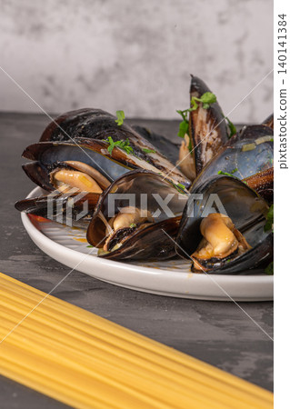 Homemade pasta spaghetti with mussels, peppers and parsley on rustic background. Sea food meal Homemade pasta spaghetti with mussels, peppers and parsley on rustic background. Sea food meal 140141384