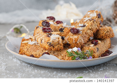 Granola bar. Healthy snack. Cereal granola bar with nuts, fruit, coconut and cranberries on a christmas table 140141397