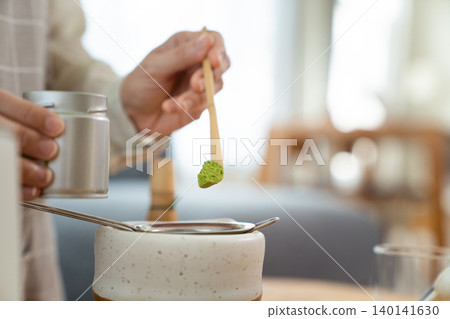 Woman whisking Matcha green tea with bamboo Chasen in bowl 140141630