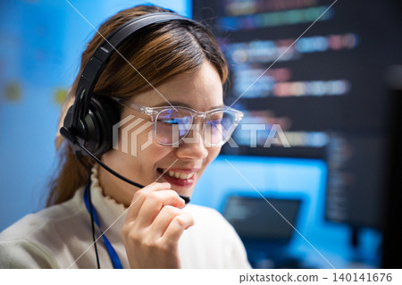 Asian woman wearing headset working as customer support agent Asian woman wearing headset working as customer support agent 140141676