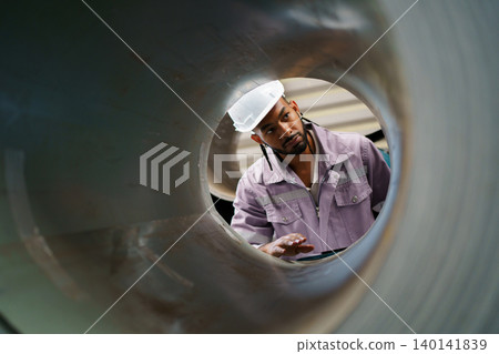 Young hispanic engineer inspecting metal roll in factory 140141839