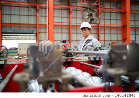 Industrial worker inspecting machineries with holding clipboard and walkie talkie 140141842