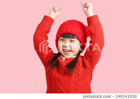 Happy Asian little girl in red sweater and hat, smiling child celebrating on pink background, winter and holiday concept,His hands were empty as if he were holding something. Happy Asian little girl in red sweater and hat, smiling child celebrating on pink background, winter and holiday concept,His hands were empty as if he were holding something. 140141910
