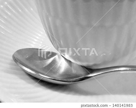 A spoon placed next to a glass (monochrome) A spoon placed next to a glass (monochrome) 140141983