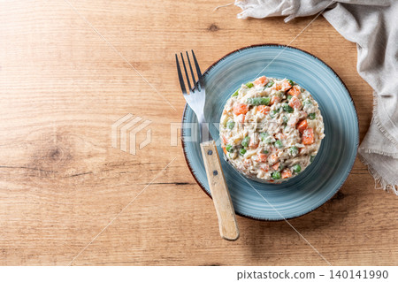 Traditional Russian salad served on plate over wooden table Traditional Russian salad served on plate over wooden table 140141990