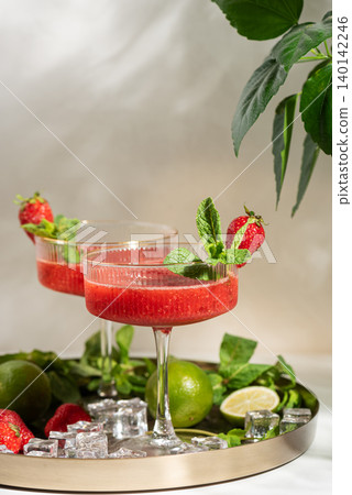 Two strawberry frozen margaritas with lime and mint Two strawberry frozen margaritas with lime and mint 140142246