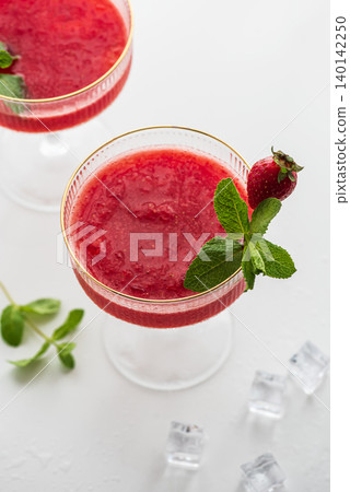 Refreshing strawberry Margarita cocktails on a white table 140142250