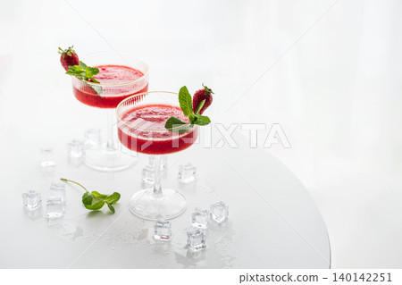Refreshing strawberry Margarita cocktails on a white table Refreshing strawberry Margarita cocktails on a white table 140142251