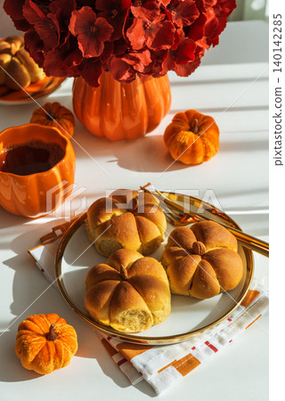 Autumn Table Setting with Pumpkin Shaped Buns with Cinnamon and Cup of Tea Autumn Table Setting with Pumpkin Shaped Buns with Cinnamon and Cup of Tea 140142285