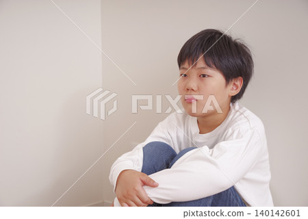 A boy whose pain is subtly conveyed through his expressionless face. A boy whose pain is subtly conveyed through his expressionless face. 140142601