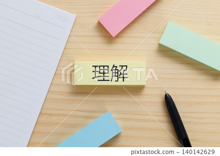 A sticky note on the desk with "Understanding" written on it; an image of understanding. A sticky note on the desk with "Understanding" written on it; an image of understanding. 140142629