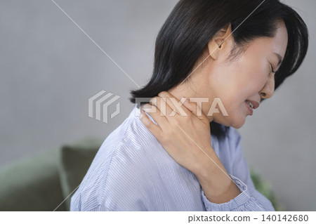 一位中年婦女用手摀住脖子,做了個鬼臉。 一位中年婦女用手摀住脖子,做了個鬼臉。 140142680