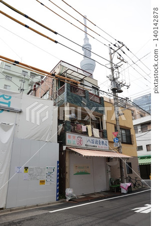 Tokyo Skytree stands between a greengrocer in the old downtown area and power lines. Tokyo Skytree stands between a greengrocer in the old downtown area and power lines. 140142878