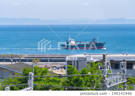 A cargo ship sailing along the blue ocean horizon and a summer seascape. A cargo ship sailing along the blue ocean horizon and a summer seascape. 140142946