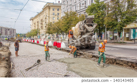 Concrete works for road maintenance construction with many workers and mixer machine timelapse Concrete works for road maintenance construction with many workers and mixer machine timelapse 140143405