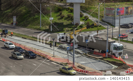 Loader crane for loading and unloading sleepers from truck which stands on a road construction site aerial timelapse Loader crane for loading and unloading sleepers from truck which stands on a road construction site aerial timelapse 140143415