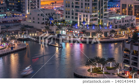 Luxury Dubai Marina canal with passing boats and promenade day to night timelapse, Dubai, United Arab Emirates Luxury Dubai Marina canal with passing boats and promenade day to night timelapse, Dubai, United Arab Emirates 140143443
