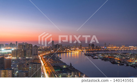 Cityscape of Ajman from rooftop day to night timelapse after sunset. 140143501