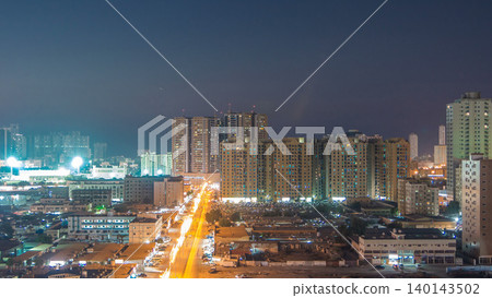 Cityscape with towers in Ajman from rooftop day to night timelapse. United Arab Emirates. 140143502