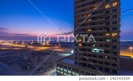 Cityscape with towers in Ajman from rooftop day to night timelapse. United Arab Emirates. 140143504