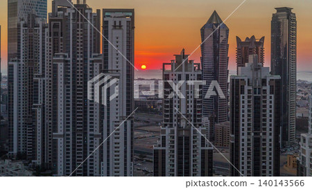Modern residential and office complex with many towers aerial timelapse at sunset in Business Bay, Dubai, UAE. Modern residential and office complex with many towers aerial timelapse at sunset in Business Bay, Dubai, UAE. 140143566