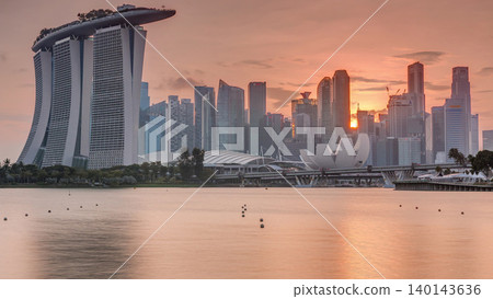 Sunset over the downtown skyline of Singapore as viewed from across the water from The Garden East timelapse. Singapore. Sunset over the downtown skyline of Singapore as viewed from across the water from The Garden East timelapse. Singapore. 140143636