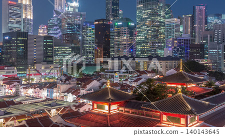 The Buddha Tooth Relic Temple comes alive at night in Singapore Chinatown day to night timelapse, with the city skyline in the background. The Buddha Tooth Relic Temple comes alive at night in Singapore Chinatown day to night timelapse, with the city skyline in the background. 140143645
