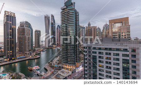 Aerial view of Dubai Marina residential and office skyscrapers with waterfront day to night timelapse Aerial view of Dubai Marina residential and office skyscrapers with waterfront day to night timelapse 140143694