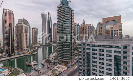 Aerial view of Dubai Marina residential and office skyscrapers with waterfront night to day timelapse Aerial view of Dubai Marina residential and office skyscrapers with waterfront night to day timelapse 140143695