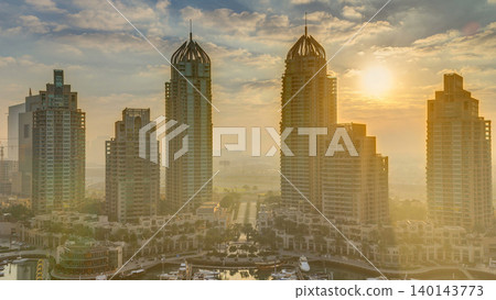 View of modern skyscrapers shining in sunrise lights timelapse in Dubai Marina in Dubai, UAE. View of modern skyscrapers shining in sunrise lights timelapse in Dubai Marina in Dubai, UAE. 140143773