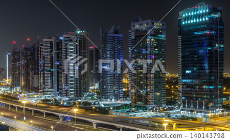 Aerial view of Jumeirah lakes towers skyscrapers during all night timelapse with traffic on sheikh zayed road. Aerial view of Jumeirah lakes towers skyscrapers during all night timelapse with traffic on sheikh zayed road. 140143798
