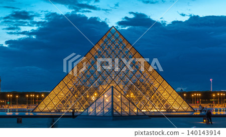 The Louvre museum pyramid after sunset day to night timelapse in Paris, France 140143914