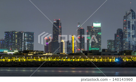 Modern Dubai city skyline timelapse at night with illuminated skyscrapers over water surface Modern Dubai city skyline timelapse at night with illuminated skyscrapers over water surface 140143960