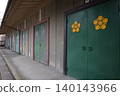 A historical architectural landscape featuring a row of storehouse doors bearing family crests. 140143966