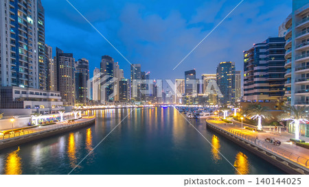 Evening Dubai marina city center with floating vessels day to night timelapse Evening Dubai marina city center with floating vessels day to night timelapse 140144025