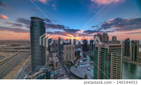 Modern skyscrapers and water channel with boats of Dubai Marina at sunset timelapse, United Arab Emirates. Modern skyscrapers and water channel with boats of Dubai Marina at sunset timelapse, United Arab Emirates. 140144052