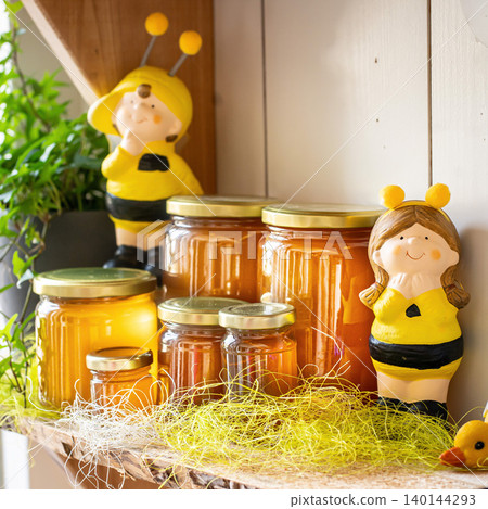 Natural honey in various jars on a wooden shelf, souvenir village market. Natural honey in various jars on a wooden shelf, souvenir village market. 140144293