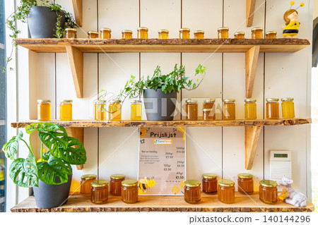 Jars of different honey varieties stocked on a shelf Jars of different honey varieties stocked on a shelf 140144296