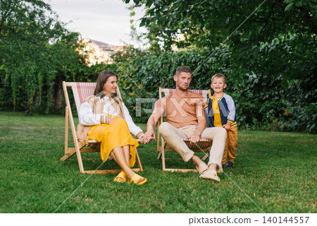 Happy Family With Pregnant Mother Sitting Outdoors Happy Family With Pregnant Mother Sitting Outdoors 140144557
