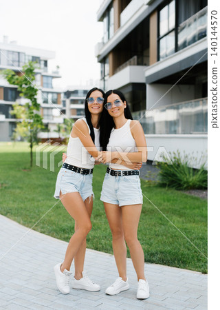 Customer Young Sisters Posing in Residential Courtyard 140144570